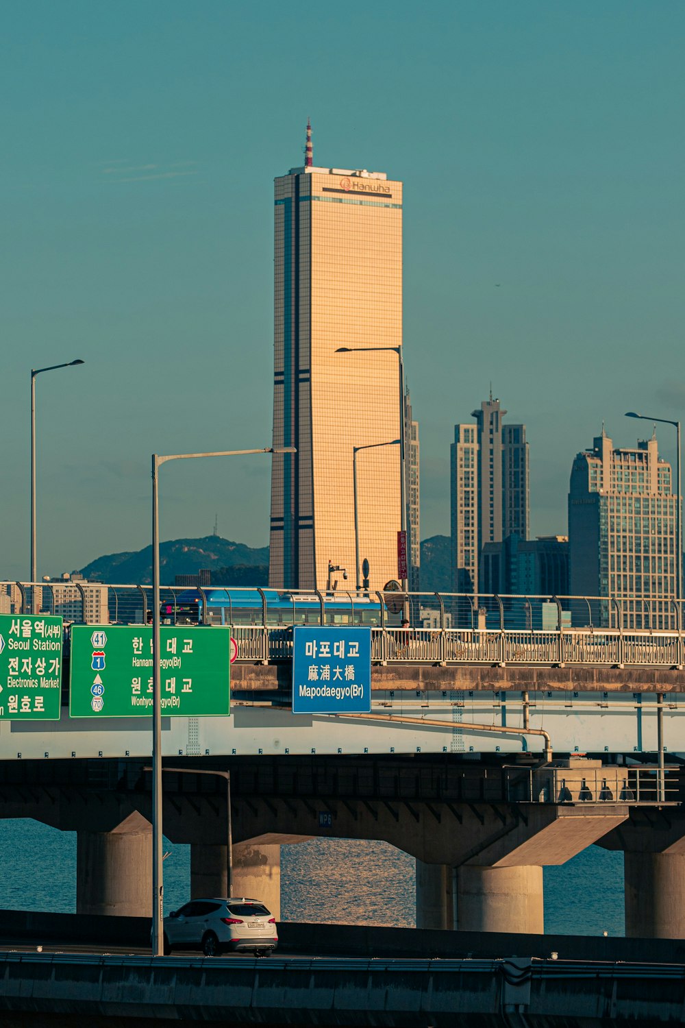 a bridge over a body of water with a city in the background