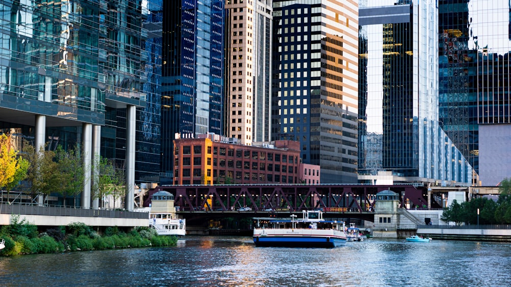 a boat traveling down a river next to tall buildings