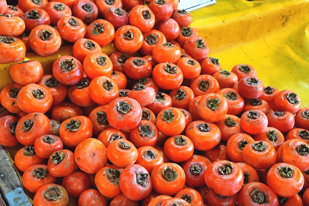 a pile of tomatoes sitting on top of a table