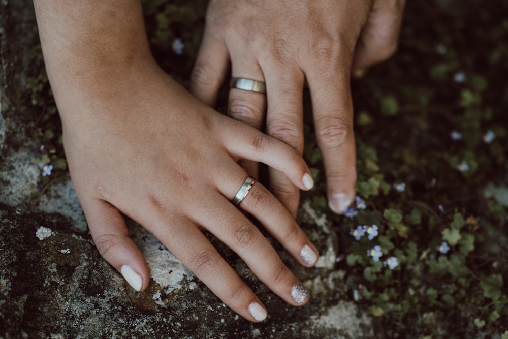 a close up of two people holding hands