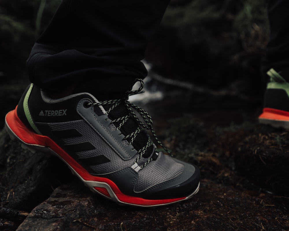 a close up of a person's shoes on a rock