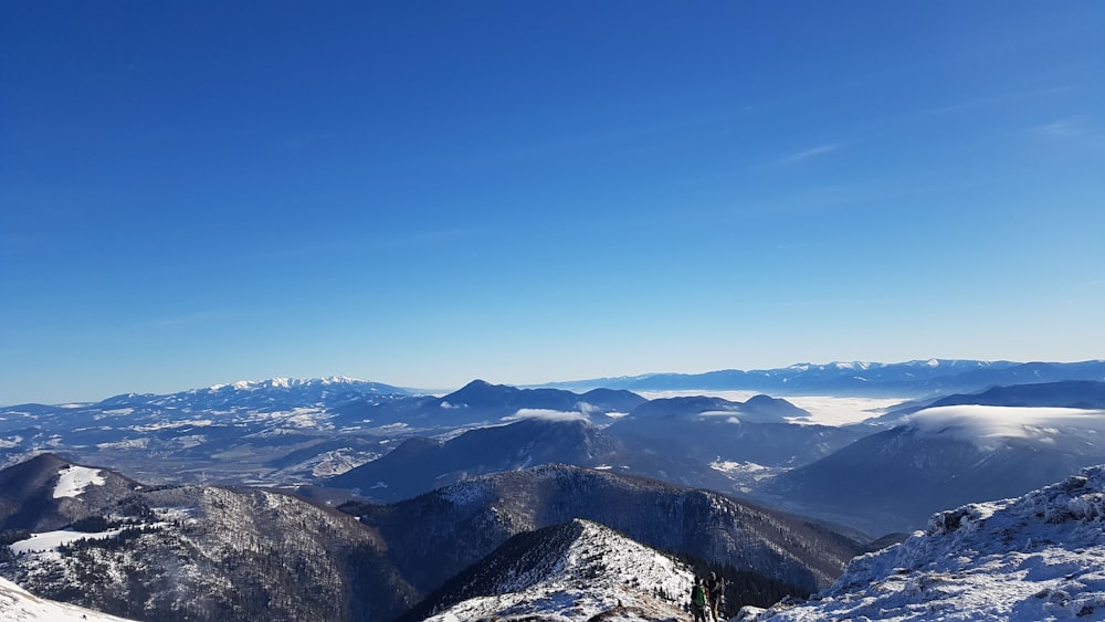 a person standing on top of a snow covered mountain