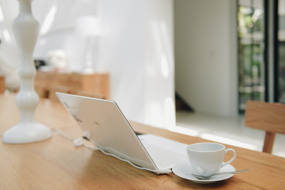 a laptop computer sitting on top of a wooden table