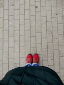 Bright red flats paired with casual denim on a sunny city sidewalk.