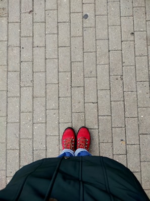 Bright red flats paired with casual denim on a sunny city sidewalk.