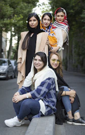 a group of women sitting next to each other on a bench