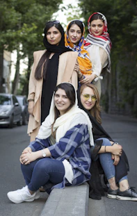 a group of women sitting next to each other on a bench