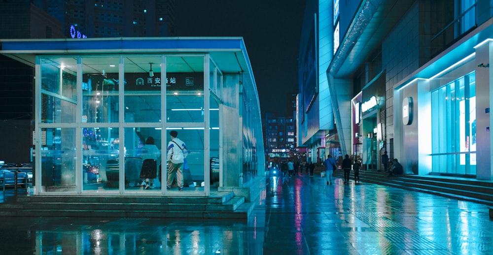 a group of people standing outside of a building at night