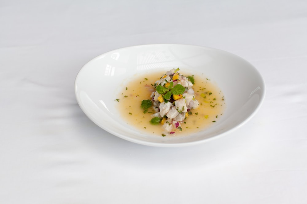 a white bowl filled with food on top of a table