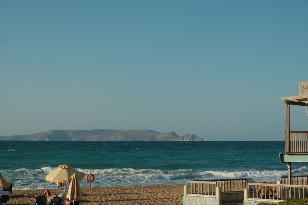 a group of people sitting on top of a sandy beach