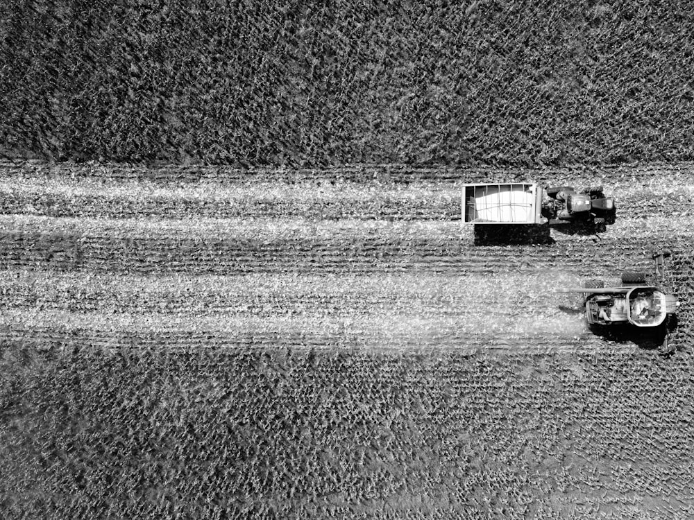 a couple of trucks driving down a dirt road