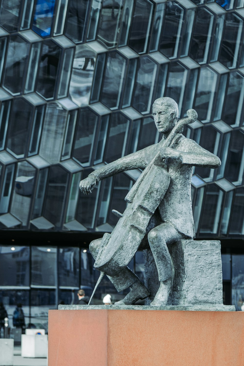 a statue of a man holding a violin in front of a building