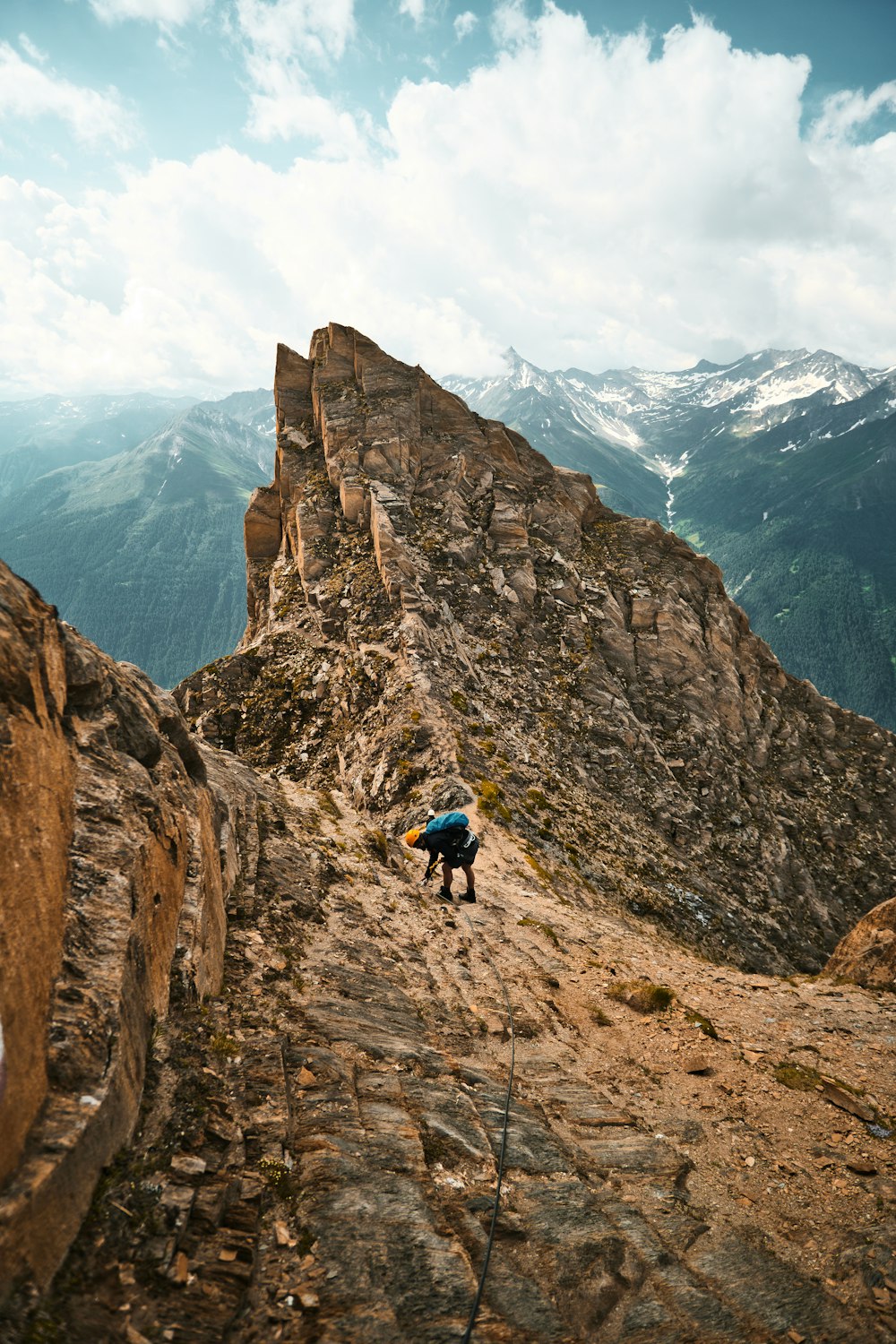 a person climbing up a mountain with a backpack