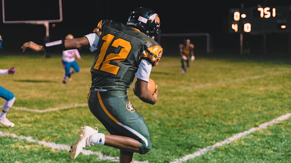 a football player running with the ball in his hand