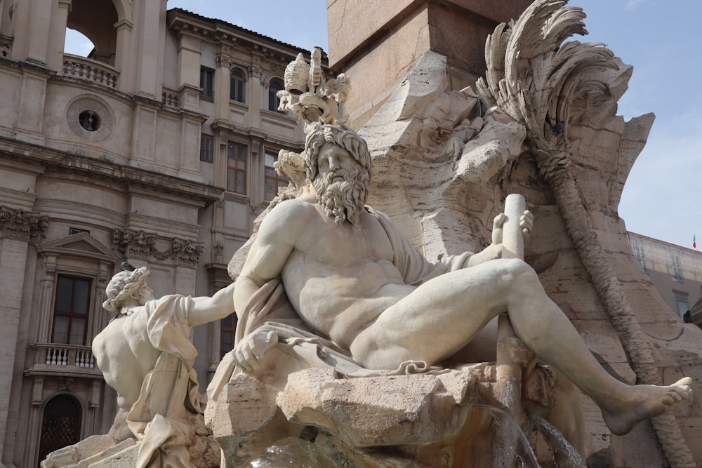 a statue of a man sitting on top of a fountain