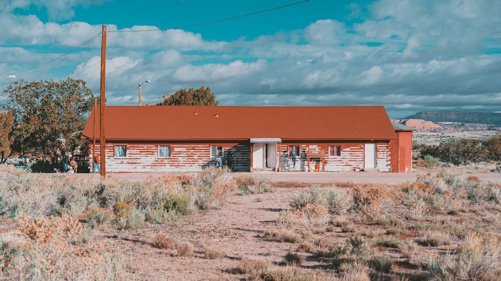 a red and white building sitting in the middle of a field