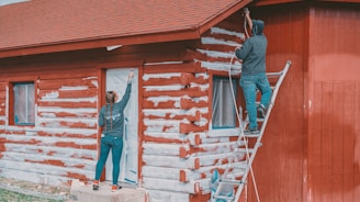 a man standing on a ladder next to a woman