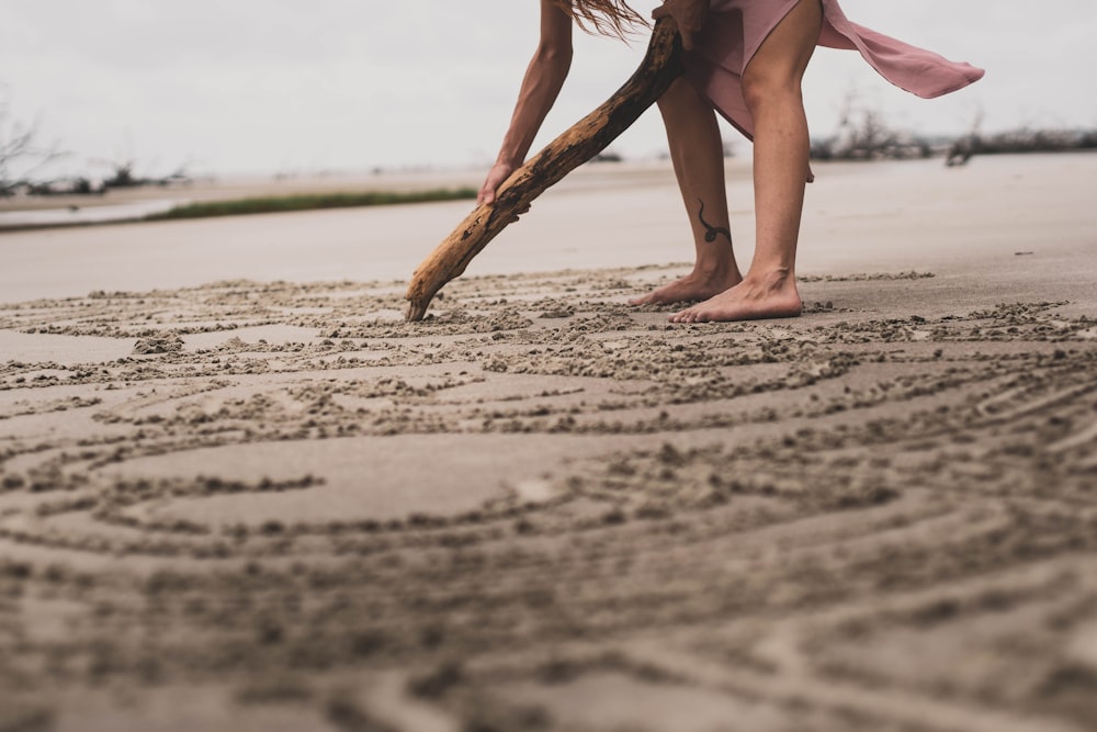 Una mujer cavando en la arena con un palo