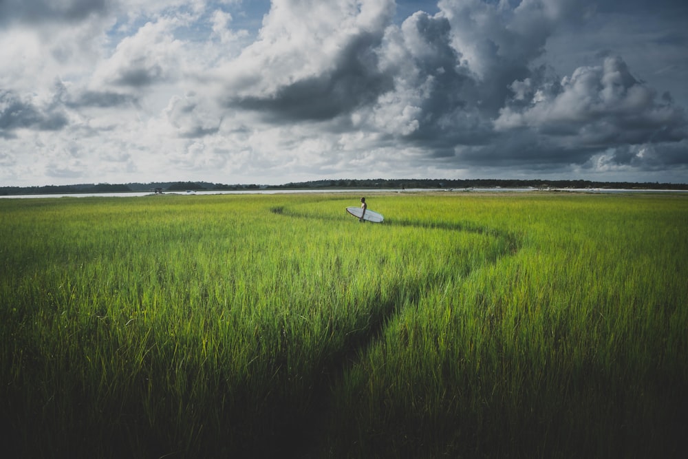 a person in a field with a surfboard