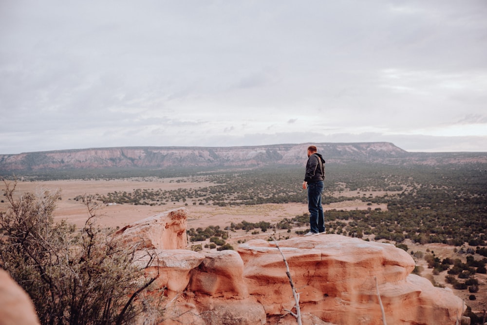 a man standing on top of a large rock