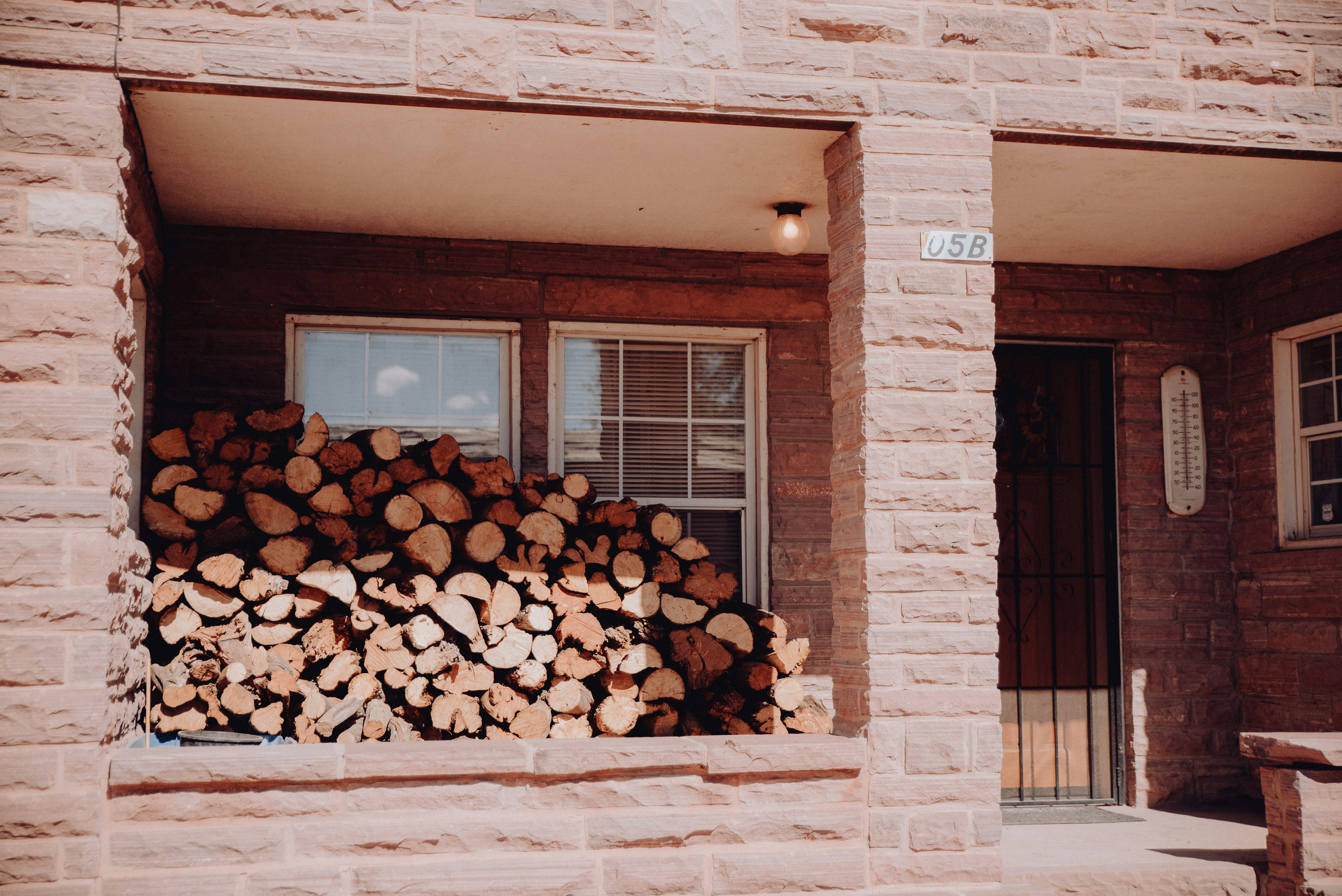 A stack of logs sitting in front of a window photo – Free Wood Image on ...