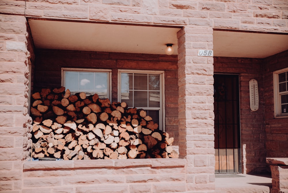 une pile de bûches assises devant une fenêtre