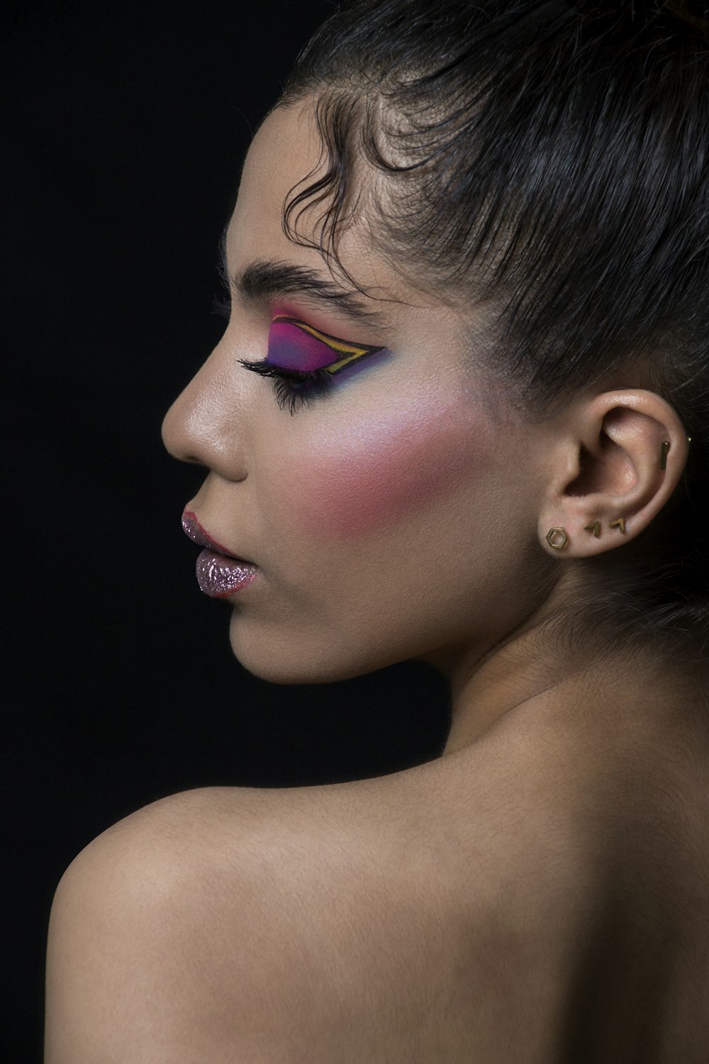 a woman with a pink and purple make up on her face