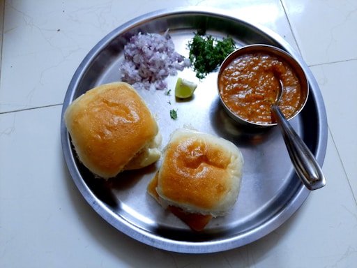 Close-up of a vibrant Pav Bhaji plate with fresh butter and bread.