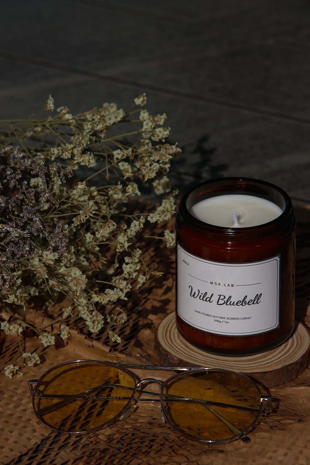 a candle, sunglasses, and flowers on a table