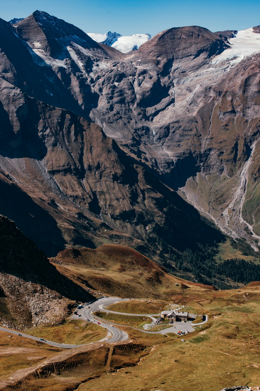 a road winding through a valley with mountains in the background