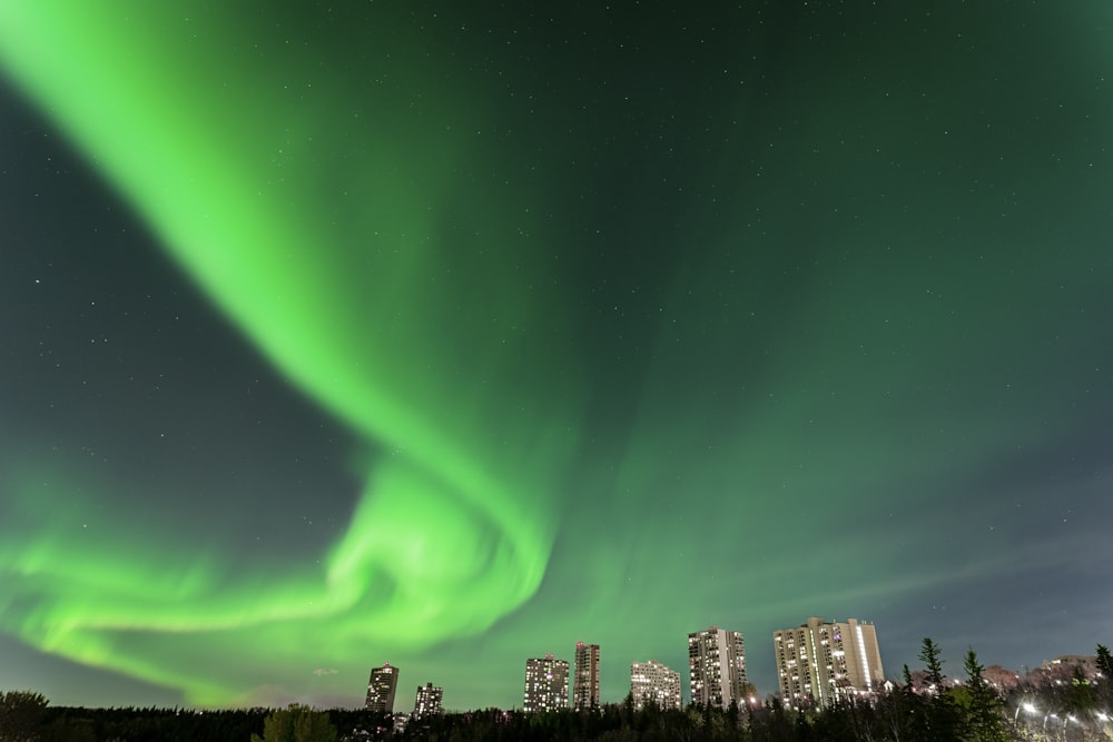 a green aurora bore in the sky over a city