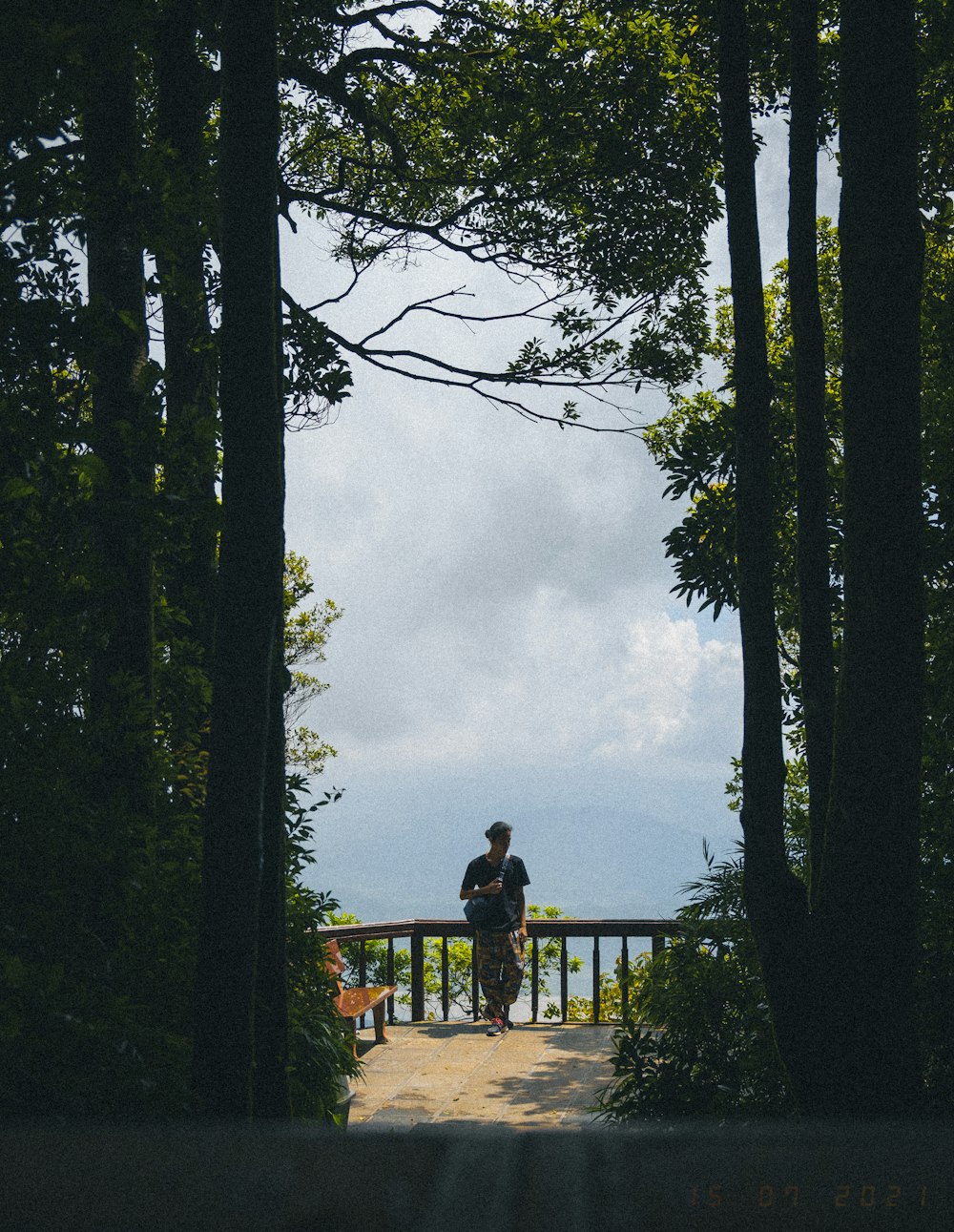 a couple of people standing on top of a wooden bridge