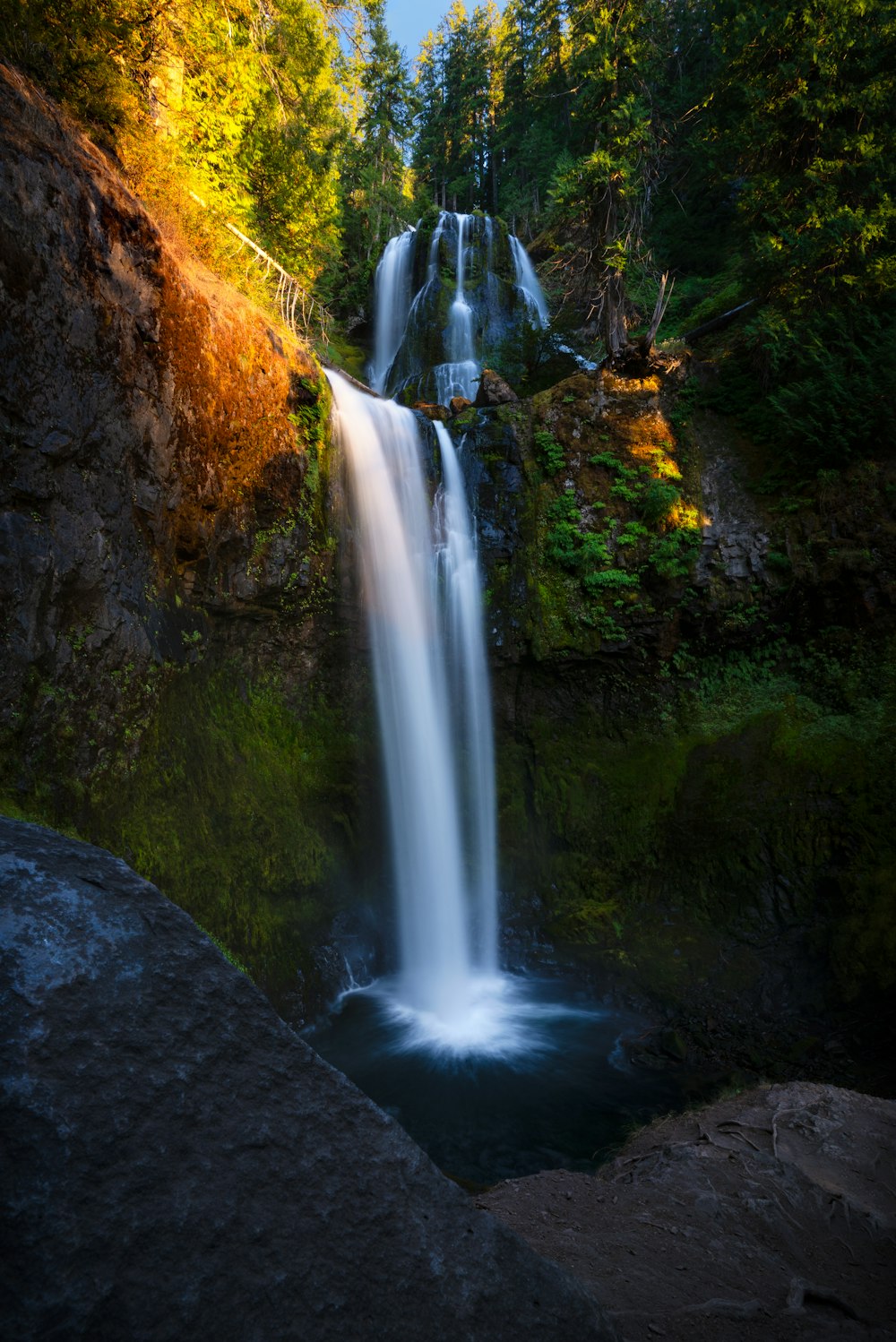 a waterfall in the middle of a forest