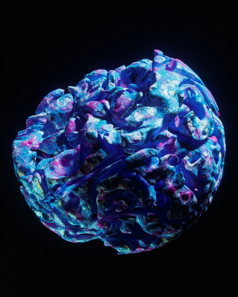 a ball of blue and purple paint on a black background