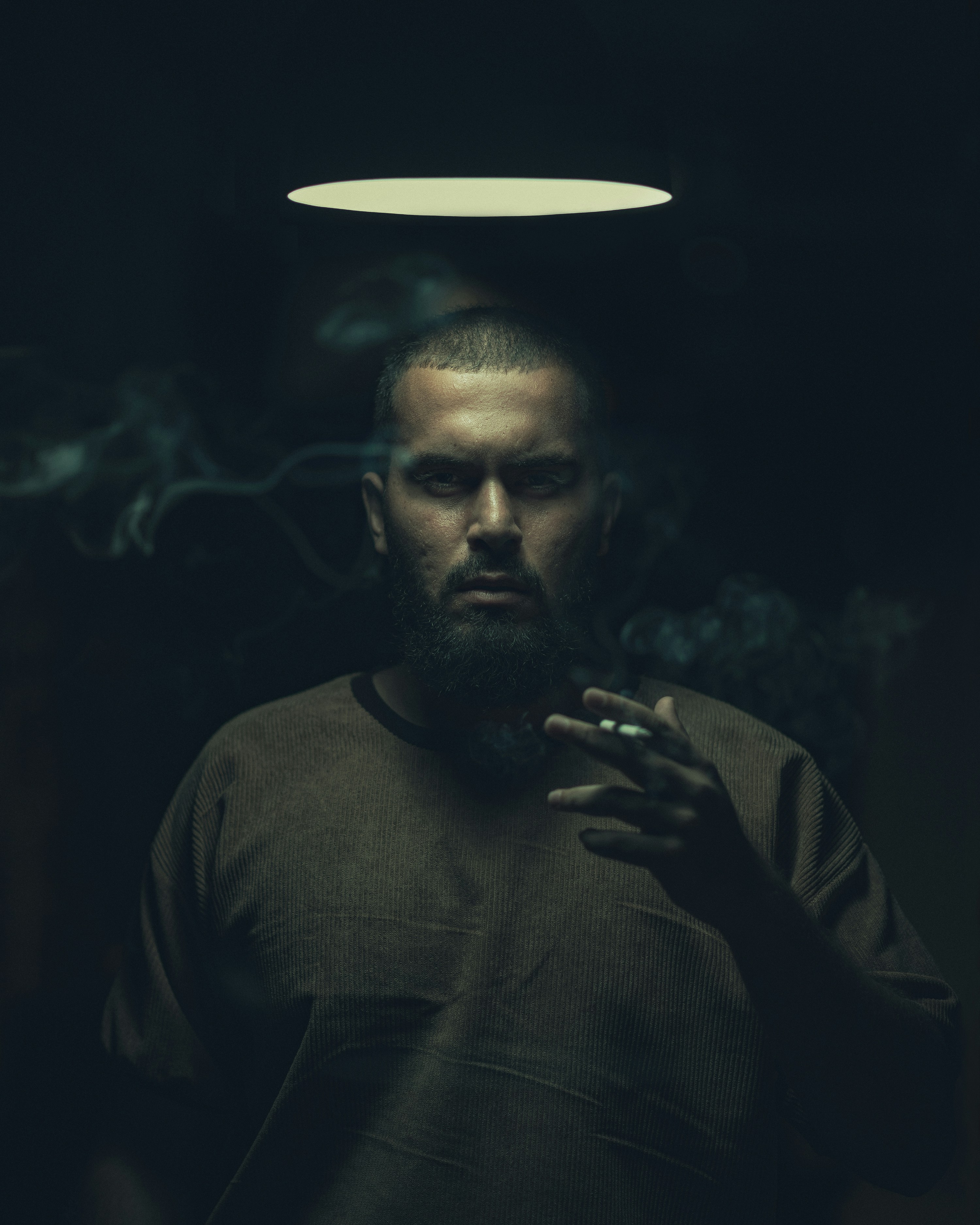 A man smoking a cigarette in a dark room photo – Free Black Image on  Unsplash