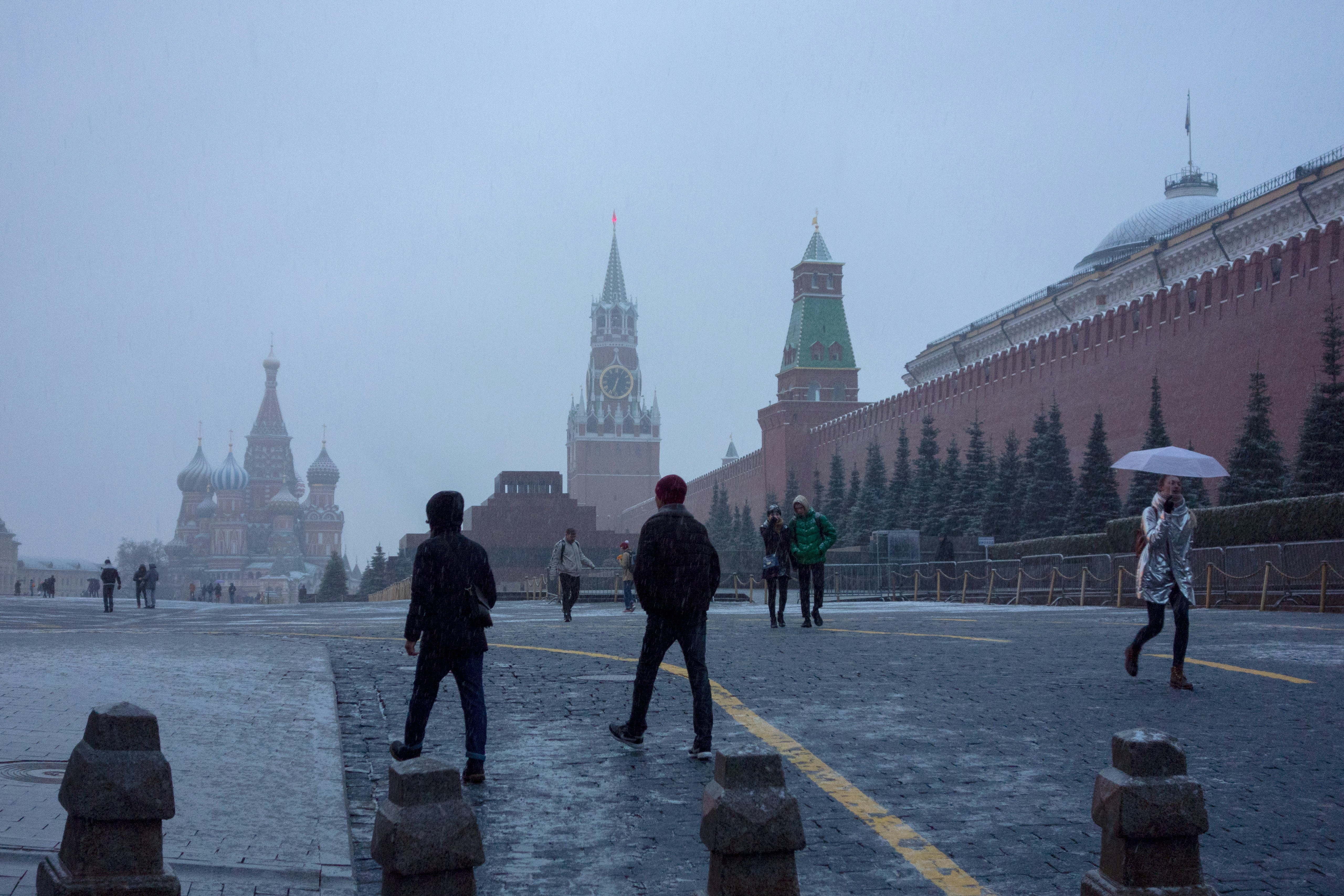 a group of people walking down a street in the rain