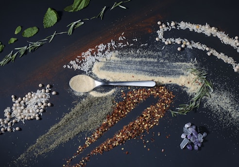 a spoon full of spices next to a pile of spices