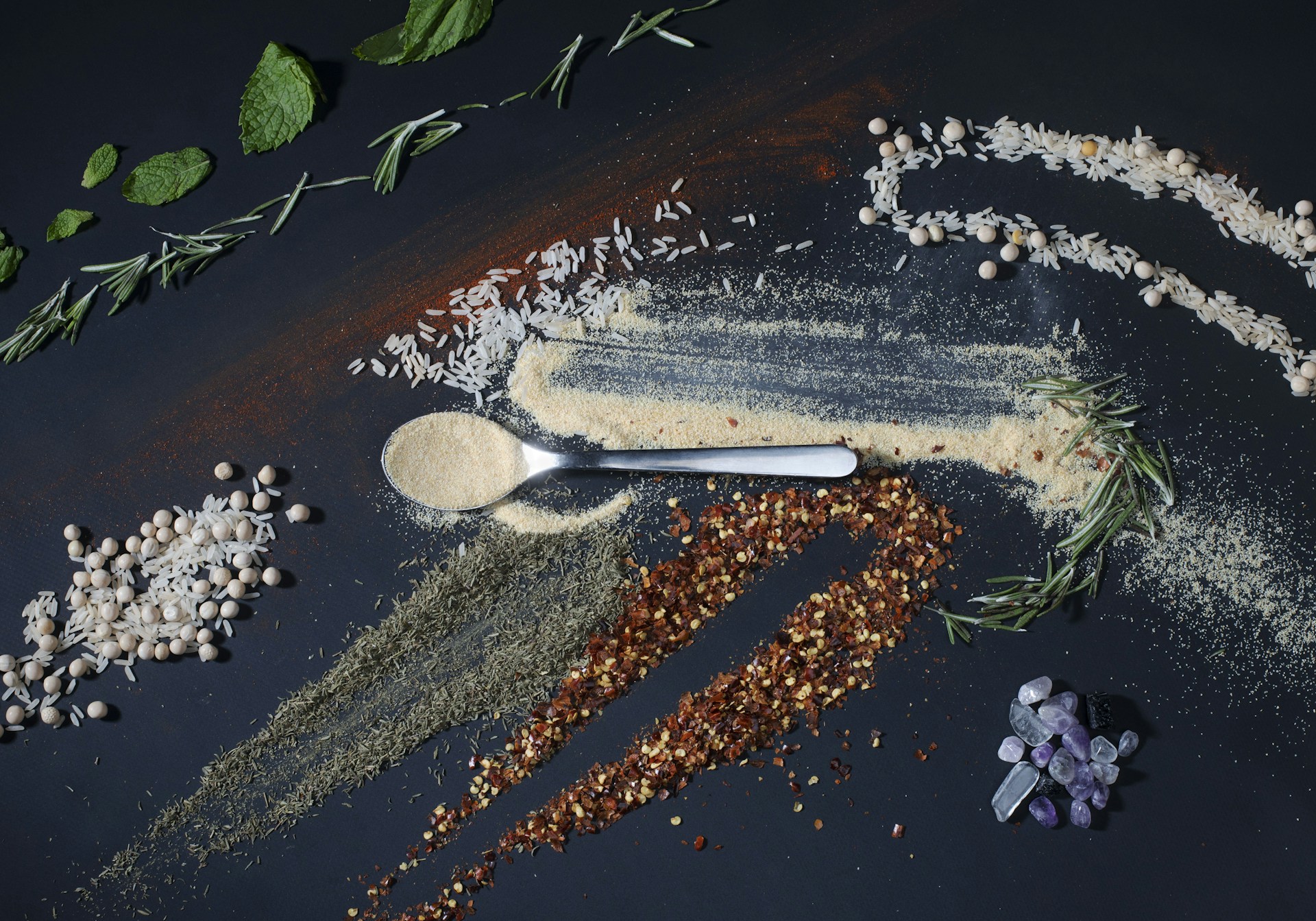 a spoon full of spices next to a pile of spices