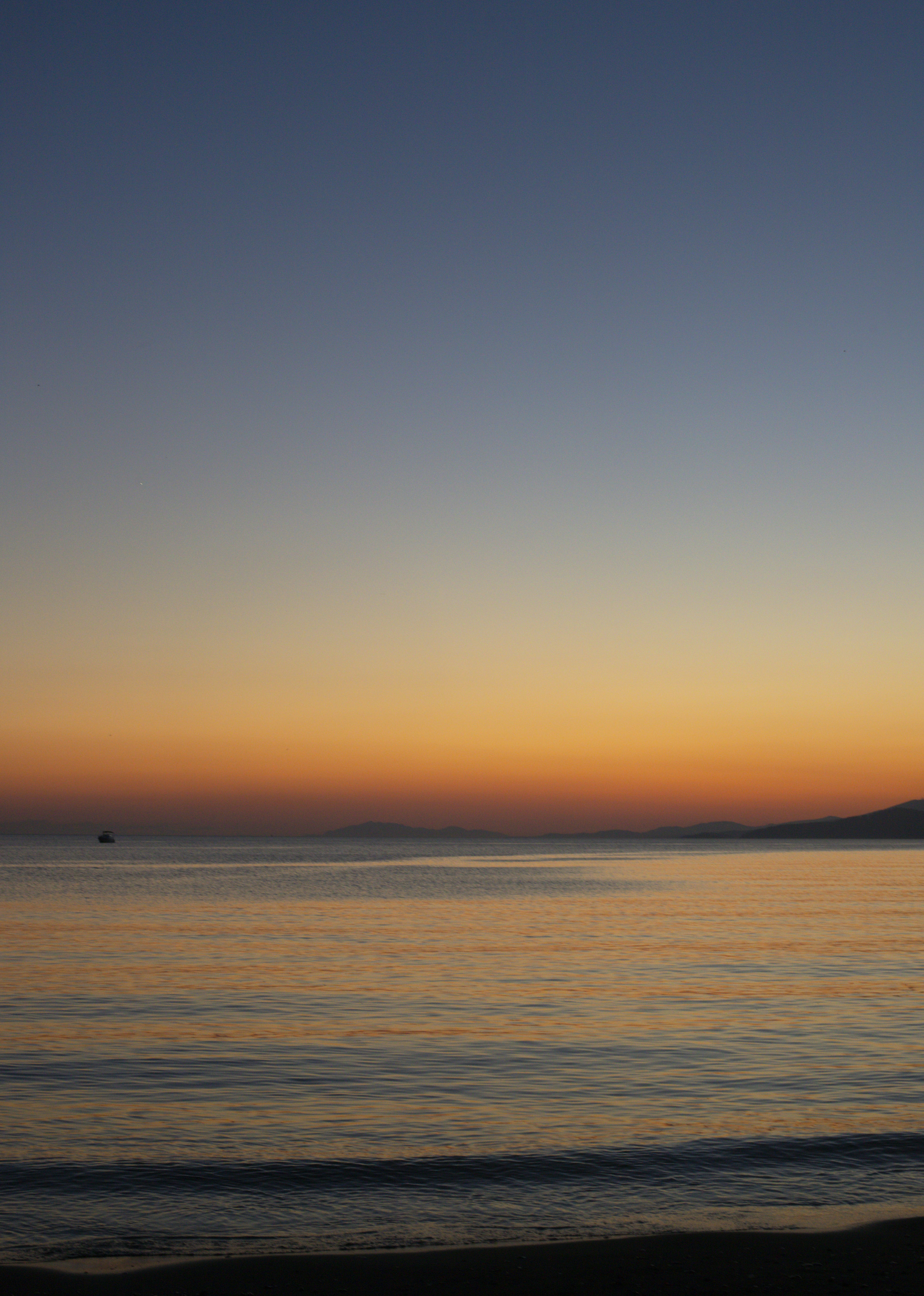 the sun is setting over the water at the beach