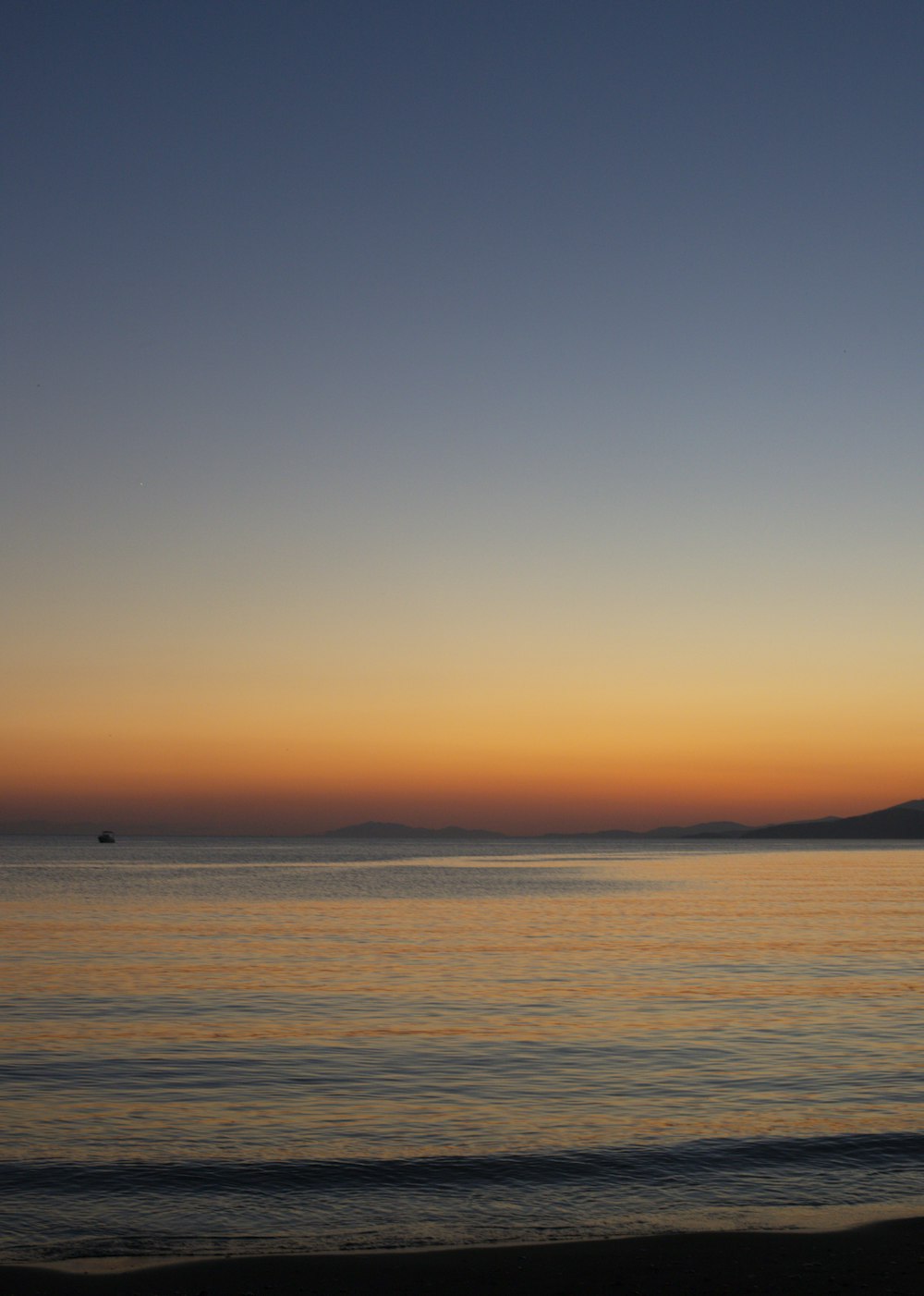 the sun is setting over the water at the beach