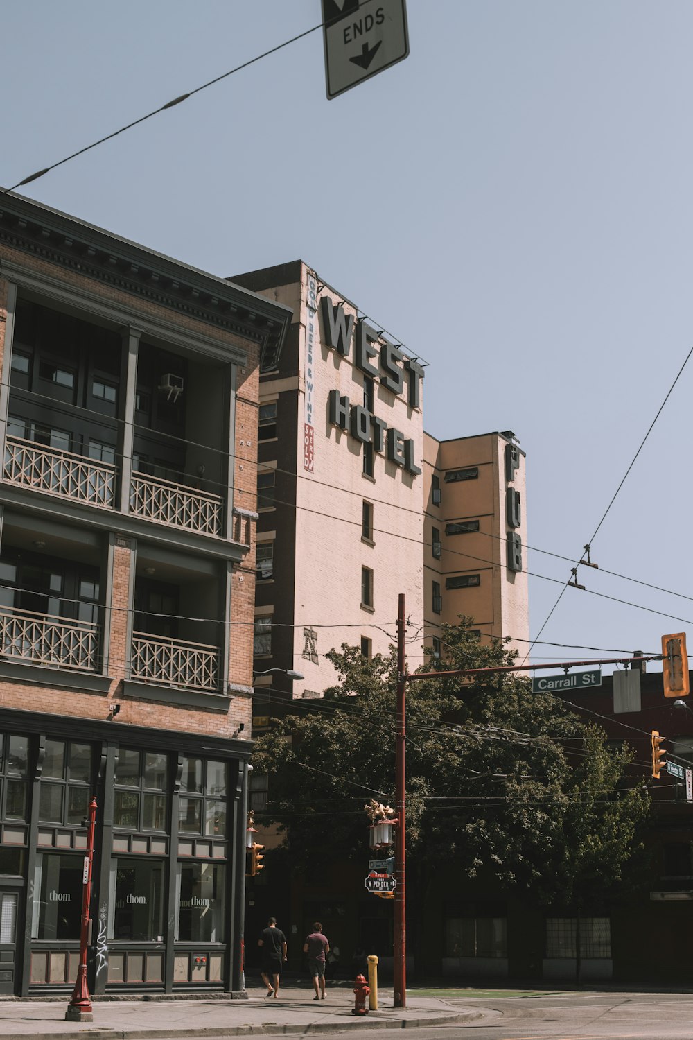 a couple of people walking down a street next to a tall building