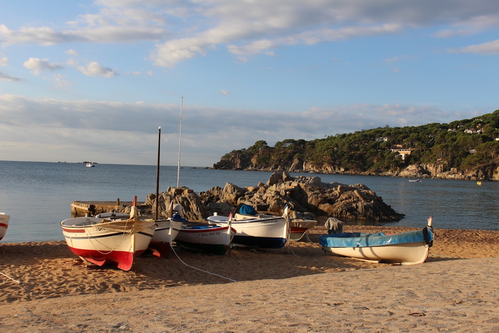 a group of boats sitting on top of a sandy beach