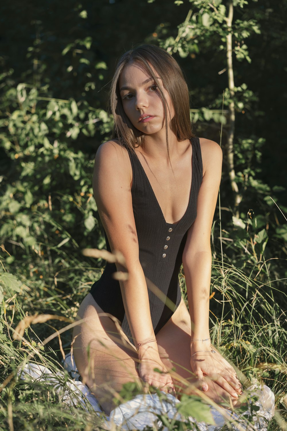 a woman in a bathing suit sitting in the grass