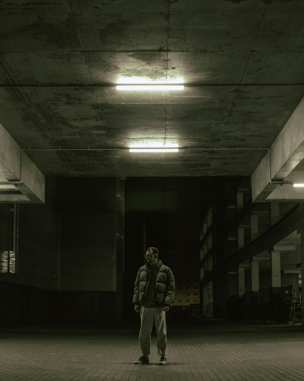 a man standing in an empty parking garage