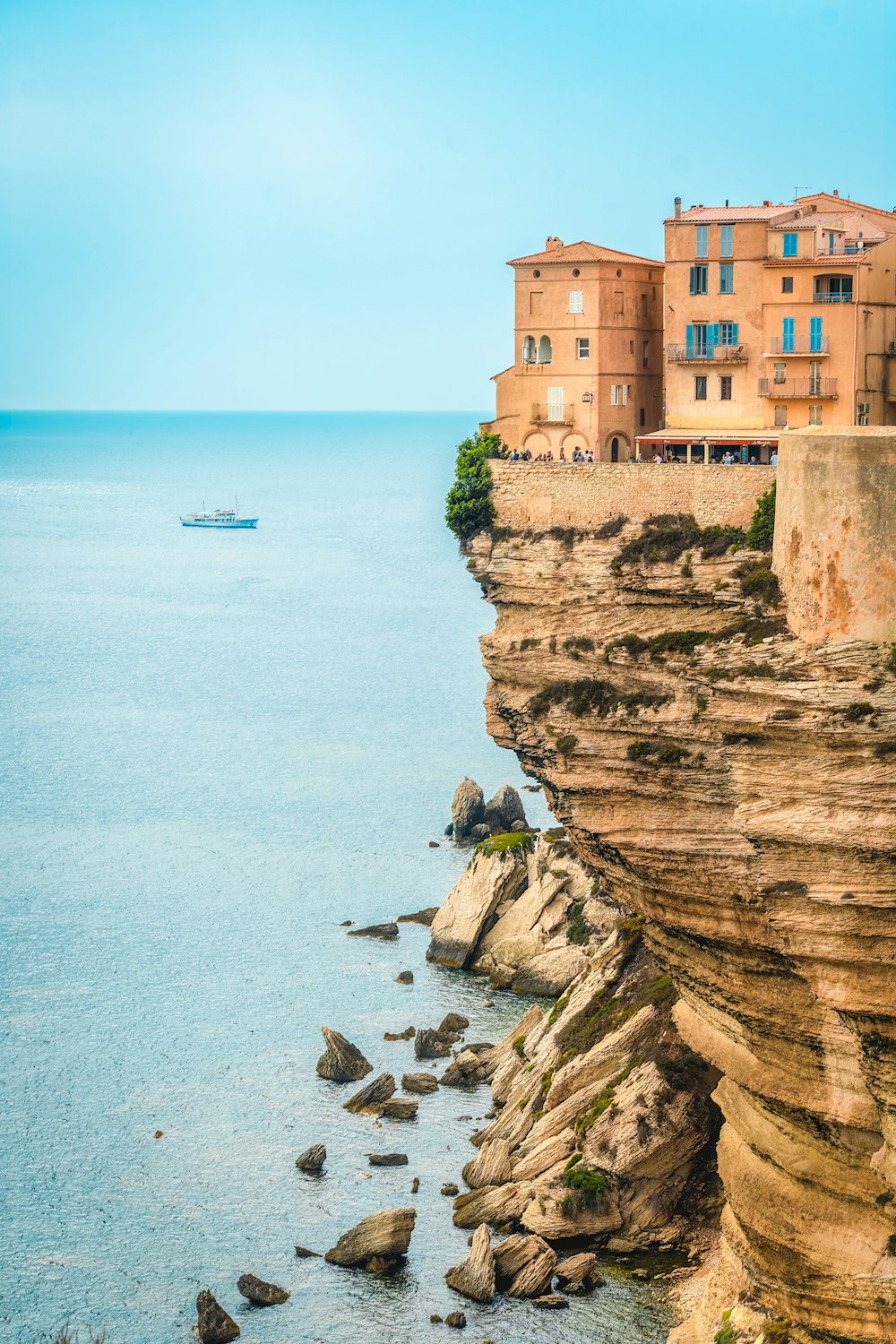 a person sitting on a rock near the ocean