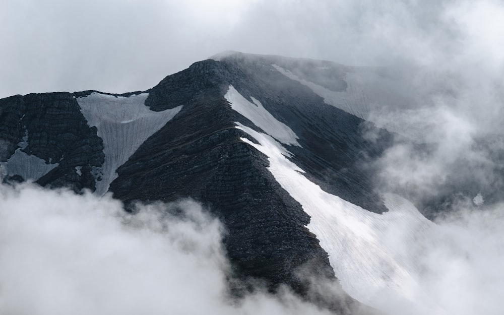 Una montaña cubierta de nieve y nubes en un día nublado