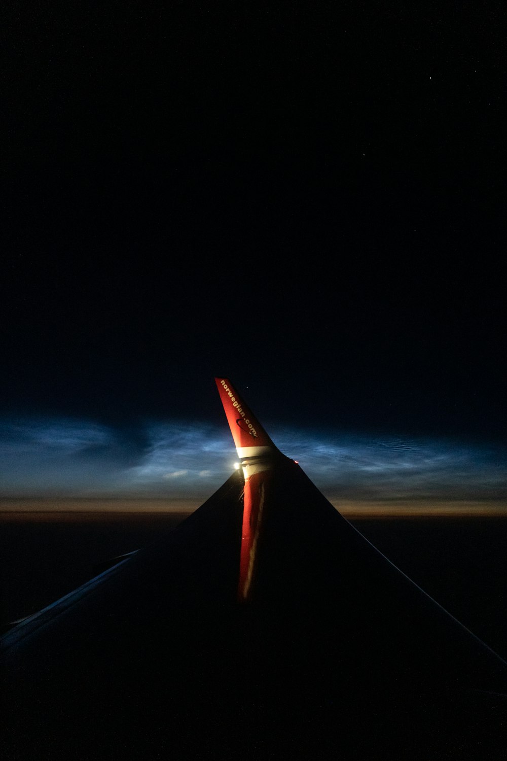 the wing of an airplane at night with the lights on