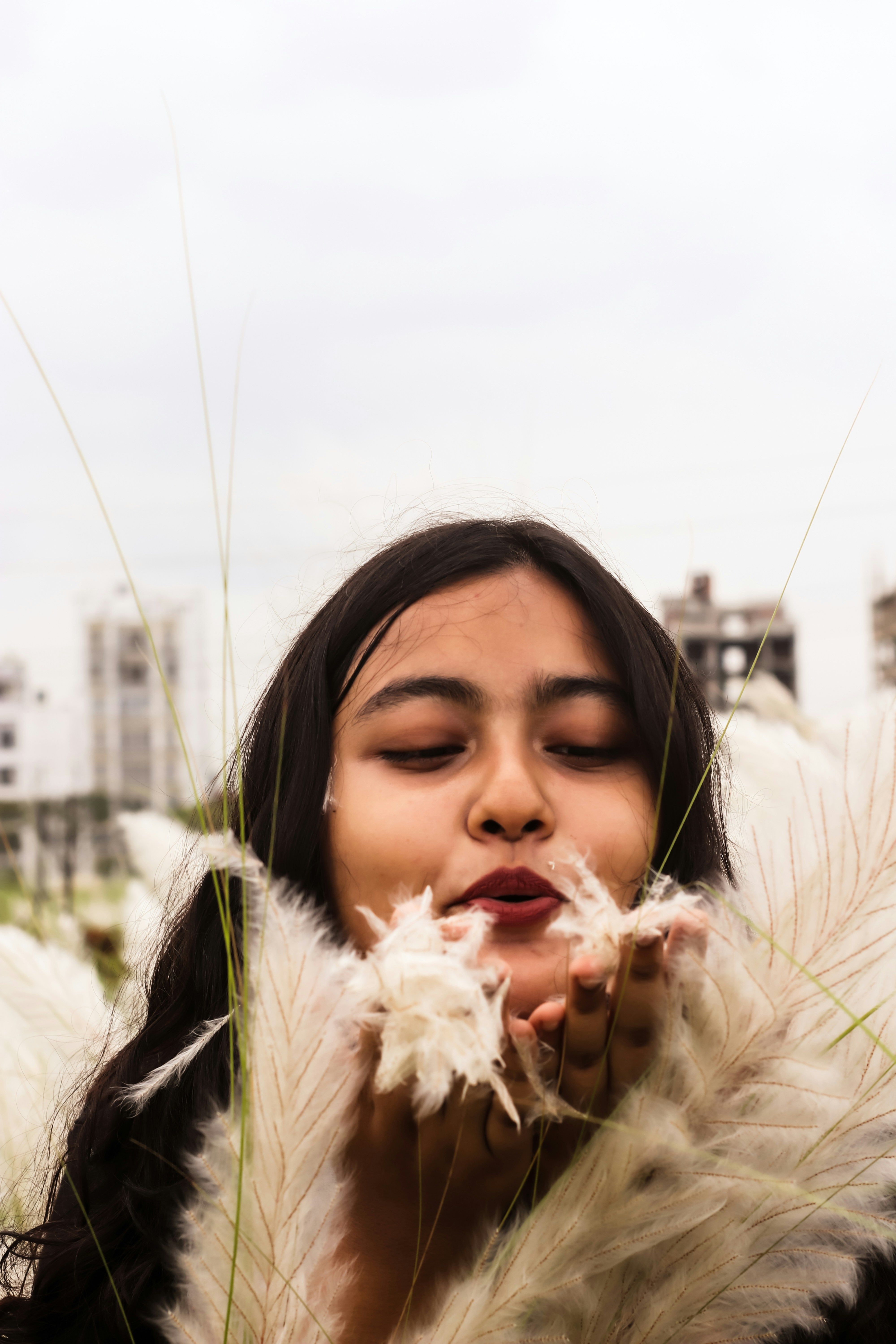 a woman with her eyes closed and her hair blowing in the wind