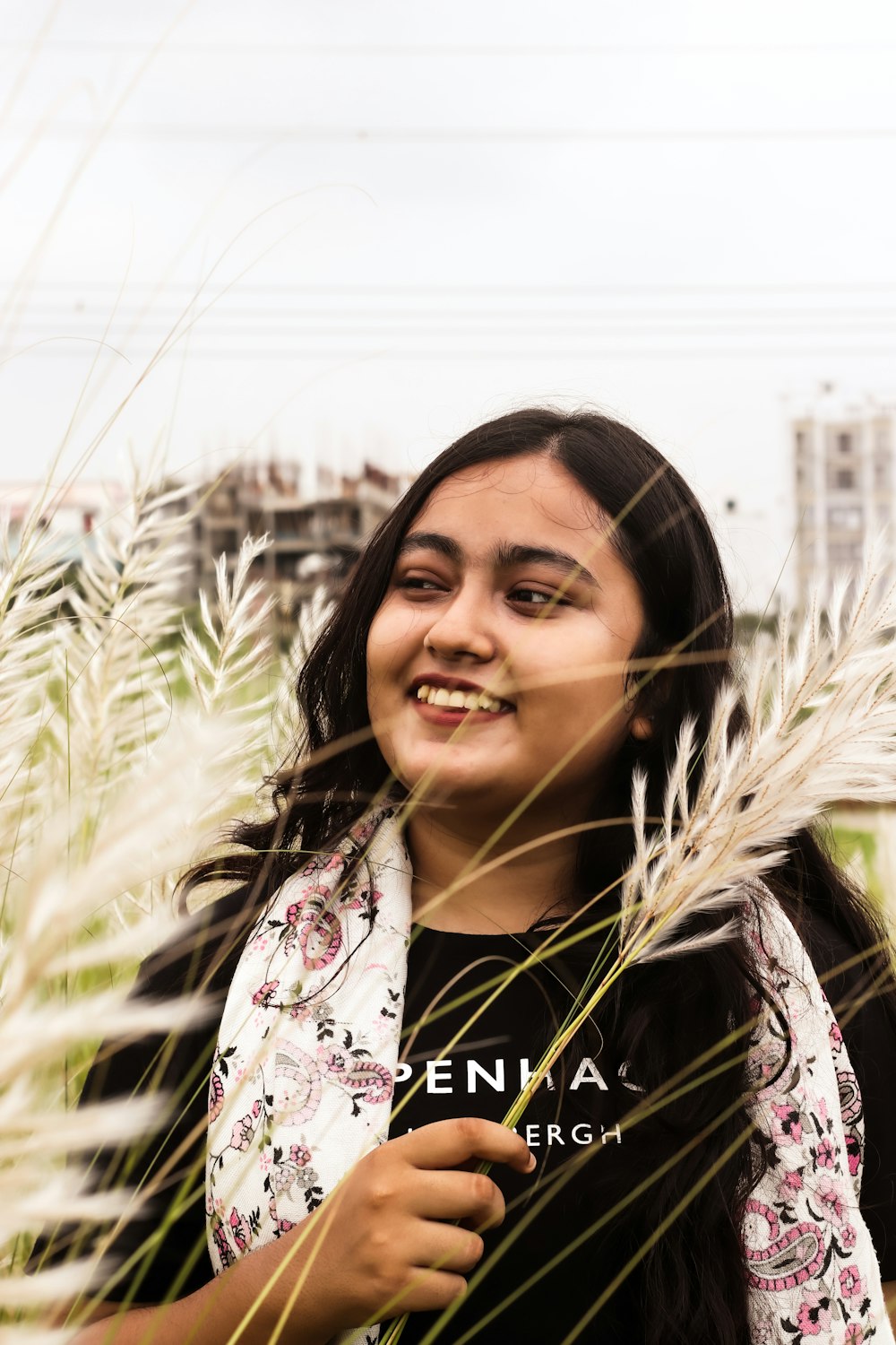 a woman standing in a field of tall grass