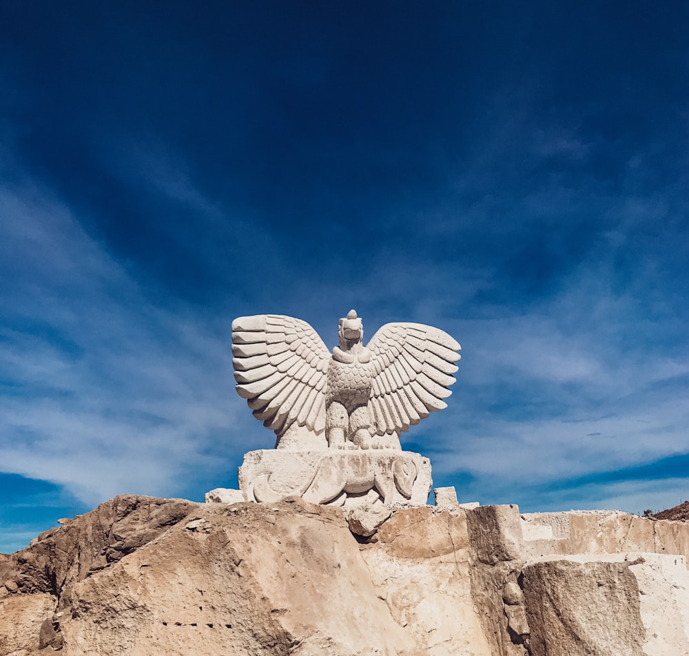 una estatua de un pájaro en la cima de una colina